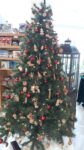 Ein festlich geschmückter Christbaum, im Hintergrund eine überdimensionale Weihnachtslaterne
